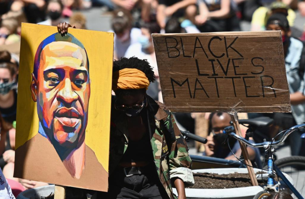 Black Lives Matter protest crowd with painted image of George Floyd