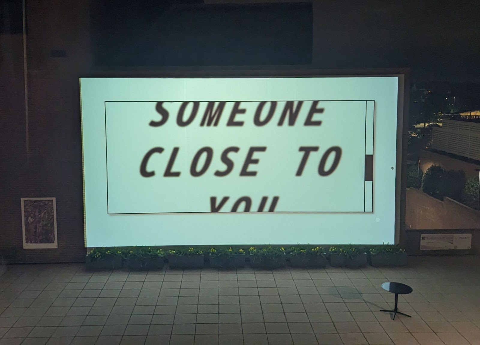 A screen inside a building that says 'Someone Close To You.'