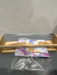 A packaged illustration ticked beneath a wooden artwork