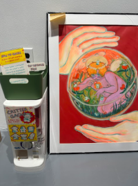 A painting of a hand, surrounding a clear orb with a child with wings on the inside of the orb
